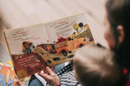 A child and woman reading a picture book